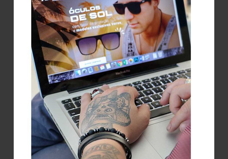 Imagem em destaque de um homem usando acessório, acessando a internet pelo notebook