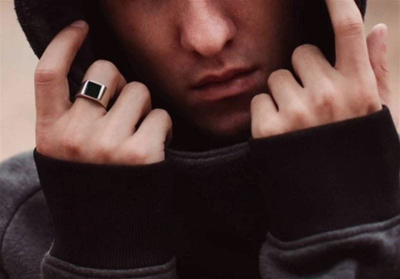 Imagem de um homem com capuz usando anel