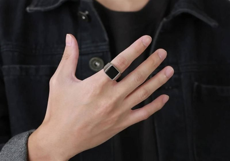 Imagem em destaque de uma mão masculina com anel no dedo indicador