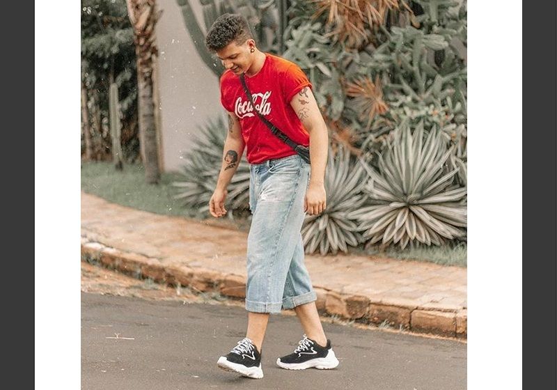 Imagem de um jovem caminhando usando roupas da tendência anos 90