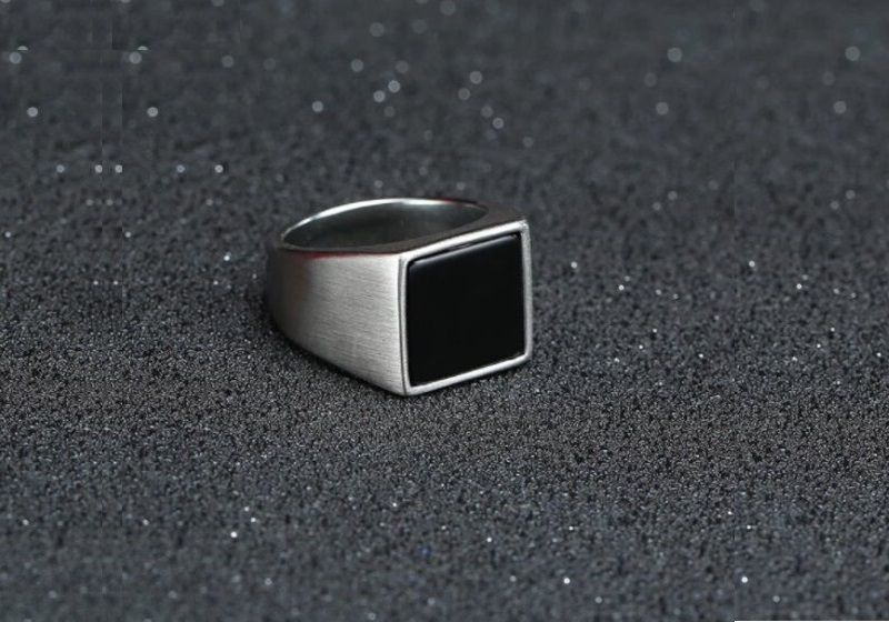 Imagem de um anel masculino prateado com pedra preta