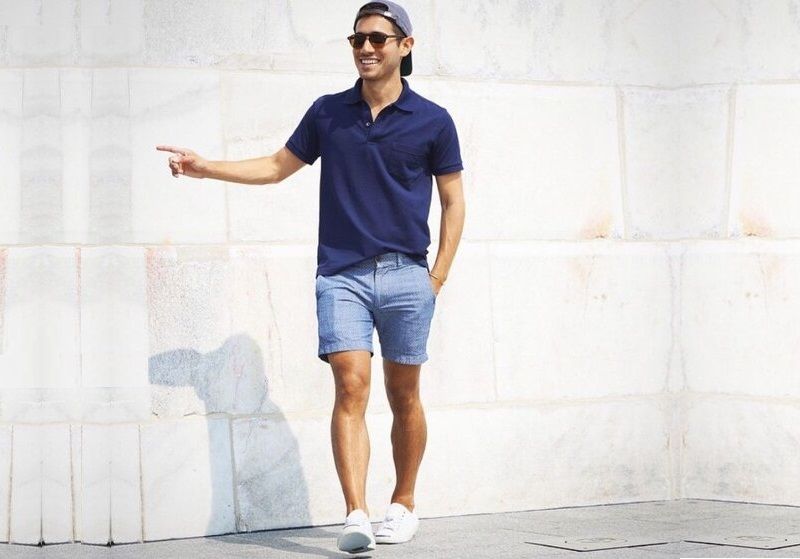 Homem andando na rua usando camisa polo e bermuda jeans