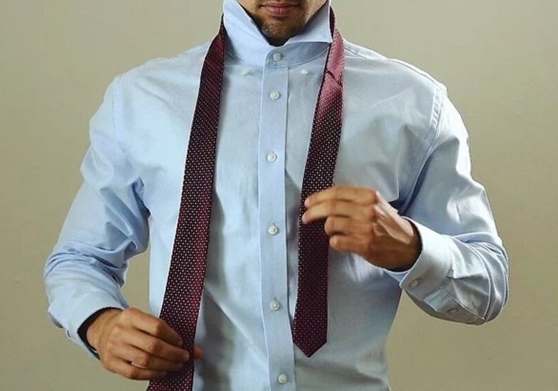 Imagem de homem passando a gravata ao redor do pescoço