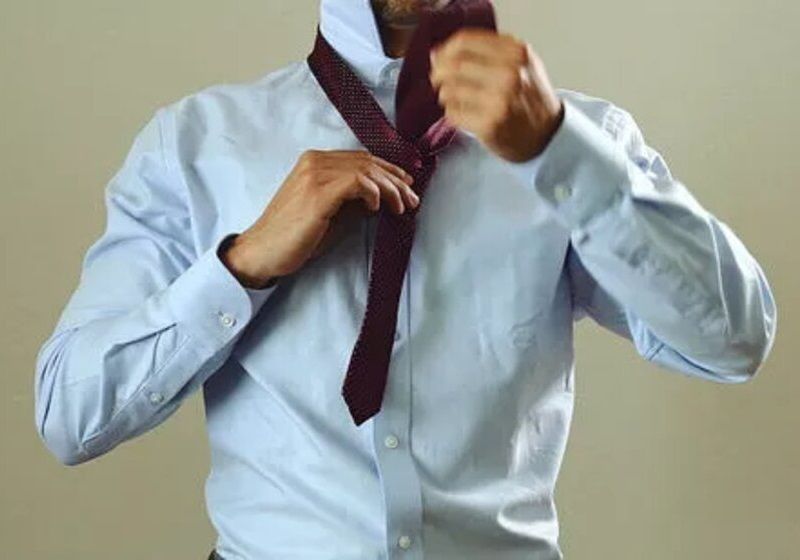 Imagem de homem cruzando a ponta mais larga da gravata