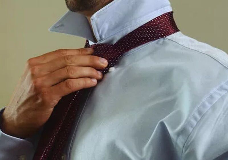 Homem escondendo a extremidade mais estreita da gravata