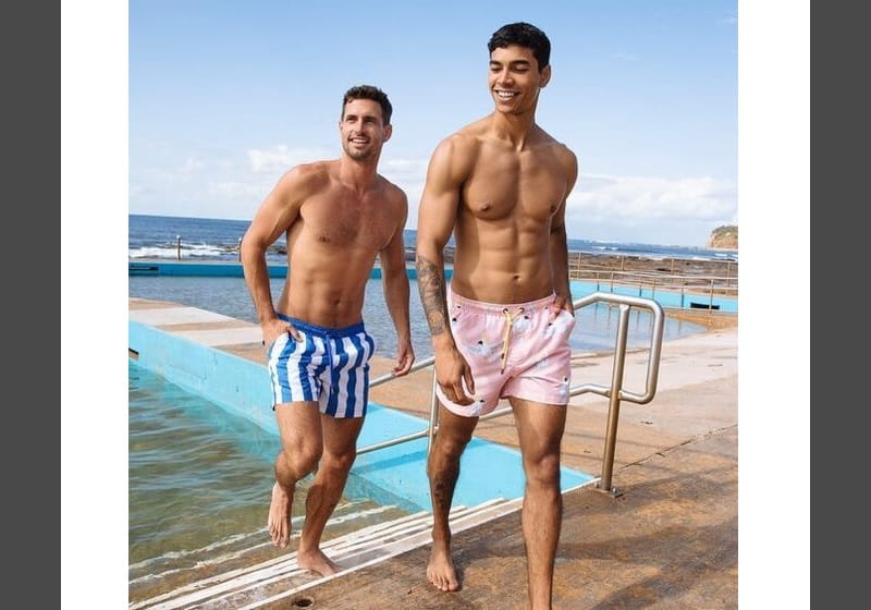 Homens na beira da praia usando shorts de tecido sintético
