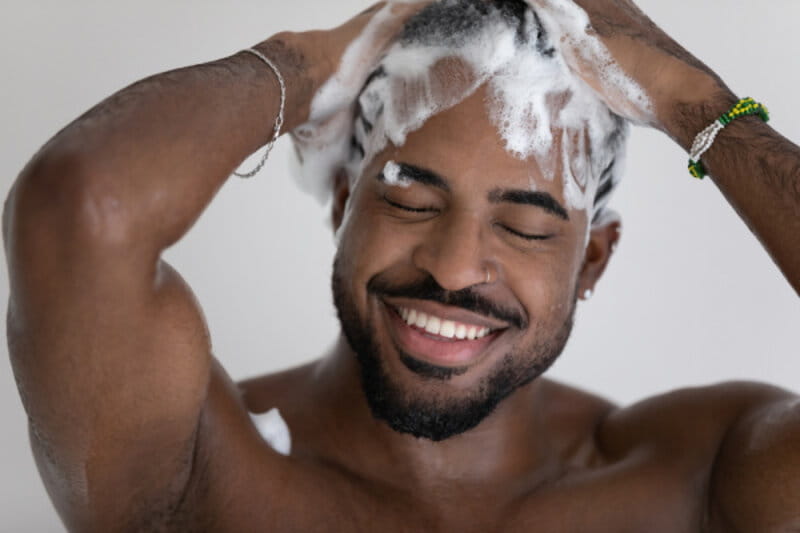 homem lavando os cabelos e sorrindo