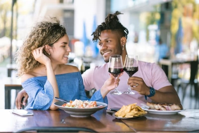 casal tomando vinho em uma mesa de restaurante